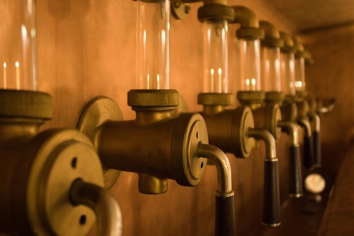 Rohre und Hähne mit Sichttunnel in einer Brauerei.